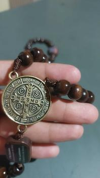 Detalhe da medalha de São Bento segurada pelo cliente