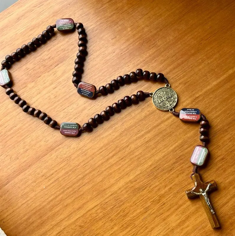 Terço completo estendido sobre mesa de madeira com todas as contas visíveis